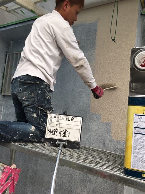 加古川市の外壁塗装工事の中塗り作業中の写真